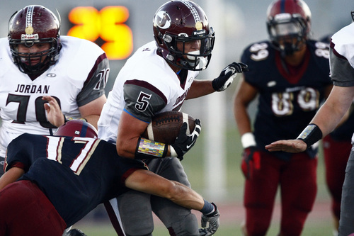 Chris Detrick  |  The Salt Lake Tribune
Jordan's Clay Moss (5) is tackled by Herriman's Braxton Thompson (17) during the game at Herriman High School Friday September 20, 2013.