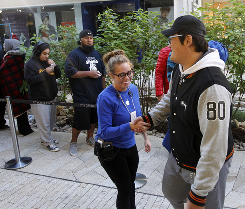 Al Hartmann  |  The Salt Lake Tribune
Apple Store employee, left, greets one of the first customers in line at City Creek Center's Apple Store early Friday morning September 20 to be among the first to purchase the new iPhone 5S.