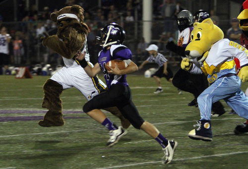 Rick Egan  | The Salt Lake Tribune 

A Lehi runner tries to out run the Bear and Rocky the Denver Nugget's mascot, during the Mascot bowl at Lehi High, Monday, September 30, 2013.