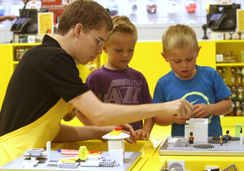 Rick Egan  | The Salt Lake Tribune 

Eric Sagaser, brick specialist, assists 5-year-olds Dylan Harrison and J. Jessop as they play with LEGOs at the new LEGO store at the Fashion Place Mall, Wednesday, Oct. 2, 2013.