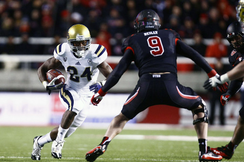 Chris Detrick  |  The Salt Lake Tribune
UCLA Bruins running back Paul Perkins (24) runs past Utah Utes defensive end Trevor Reilly (9) during the second half of the game at Rice-Eccles Stadium Thursday October 3, 2013. UCLA is winning the game 24-17.
