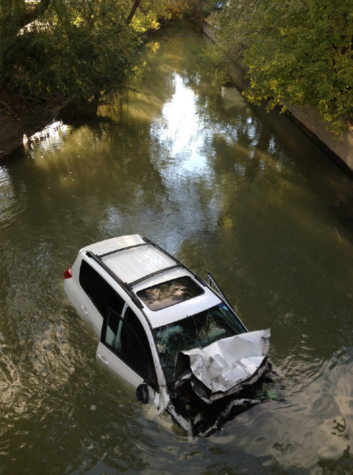 (Chris Detrick | The Salt Lake Tribune) A car plunged into a canal in Murray on Friday afternoon, leaving two people in serious condition.