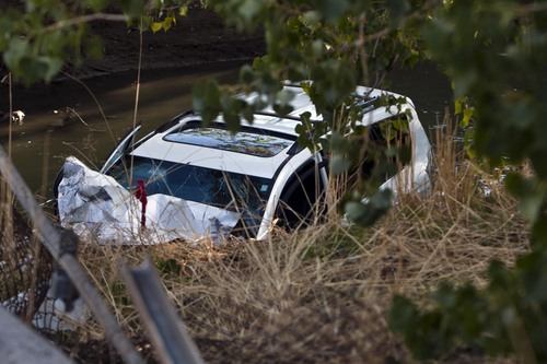 Chris Detrick  |  The Salt Lake Tribune
A car plunged into a canal in Murray, leaving two people in serious condition Friday October 4, 2013. A four-car accident sent at least one vehicle into a canal in Murray on Friday afternoon and left several people in serious condition. The accident happened about 4:30 p.m. near 4200 S. State Street, according to Unified Police spokesman Ken Hansen.