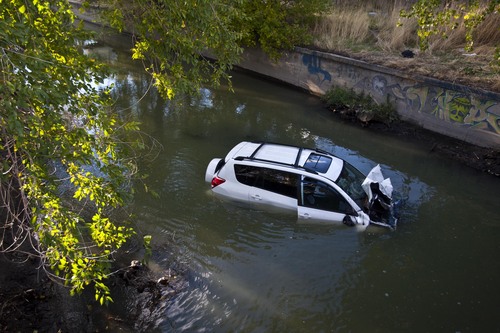 Chris Detrick  |  The Salt Lake Tribune
A car plunged into a canal in Murray, leaving two people in serious condition Friday October 4, 2013. A four-car accident sent at least one vehicle into a canal in Murray on Friday afternoon and left several people in serious condition. The accident happened about 4:30 p.m. near 4200 S. State Street, according to Unified Police spokesman Ken Hansen.