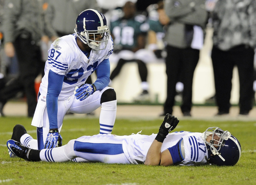 Indianapolis Colts wide receiver Austin Collie, right, lies on the field after being injured as teammate Reggie Wayne, center, looks on, while back judge Todd Prukop walks nearby during the first half of the Colts' NFL football game against the Philadelphia Eagles, Sunday, Nov. 7, 2010 in Philadelphia. (AP Photo/Miles Kennedy)