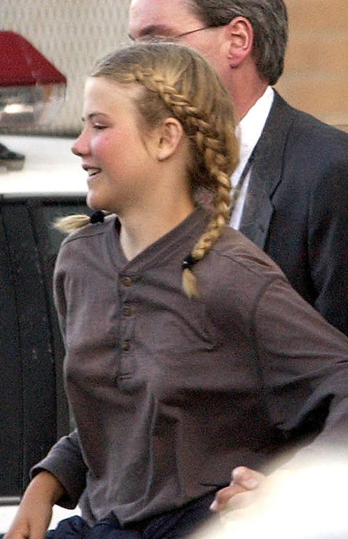 FILE - In this March 12, 2003, file photo, Elizabeth Smart is rushed into an unmarked van from the Salt Lake City Police department and taken to her home, in Salt Lake City. More than a decade after her kidnapping and rescue grabbed national headlines, Elizabeth Smart is publishing a memoir of her ordeal. The 308 page book, titled "My Story," is being released by St. Martin's Press on Monday, Oct. 7, 2013. (AP Photo/The Salt Lake Tribune, Francisco Kjolseth, File) DESERET NEWS OUT; LOCAL TV OUT; MAGS OUT