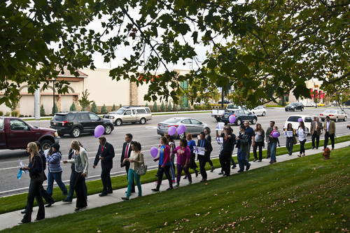 Chris Detrick  |  The Salt Lake Tribune
People participate during a march to support domestic violence victims at West Valley City Hall Tuesday October 8, 2013. The city is displaying more than 40 metal silhouettes in city hall to represent each person killed in a domestic violence homicide in the history of West Valley City.