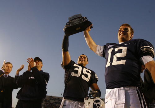 Provo,UT--11/18/06-5:16:43 PM--
BYU captains John Beck #12 and Cameron Jensen hold up the Mountain West Conference Championship trophy  after the game.
***
BYU v University of New Mexico.
2nd half

Chris Detrick/Salt Lake Tribune
File #_2CD4529