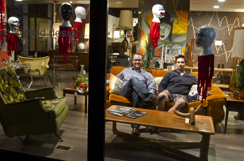 Keith Johnson | The Salt Lake Tribune
 
Mod a-go-go owners Eric Morley, left, and Marcus Gibby sit in the front window of their furniture consignment store on South Temple in Salt Lake City, October 9, 2013. Their store features 50's and 60's style furniture as well as original art by local artists. Mod a-go-go is in the renovated King's Row Formal Wear building at 242 E. S. Temple.