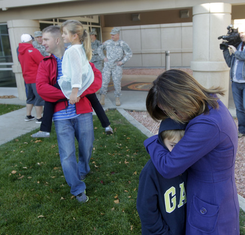 Al Hartmann  |  The Salt Lake Tribune
Traci Brahnham hugs her son Preston as her husband Lt. Col. Matthew Branham holds his daughter Addison at Camp Williams.  Thirteen members of the Utah National Guard 115th Engineer Facilities Detachment left  Camp Williams Tuesday Oct. 15 for deployment to Afghanistan for one year.