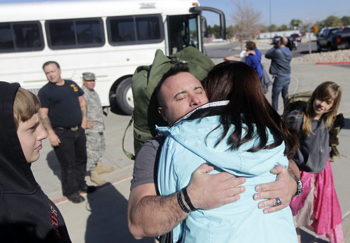 Al Hartmann  |  The Salt Lake Tribune
Sgt. 1st Class Jason Lyday hugs his wife Amanda as his children watch before boarding a bus at Camp Williams. They are from Eagle Mountain.  He is among 13 members of the Utah National Guard's 115th Engineer Facilities Detachment that left Camp Williams Tuesday Oct. 15 for deployment to Afghanistan for one year.