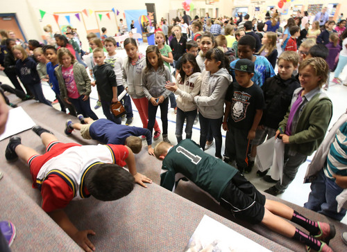 Francisco Kjolseth  |  The Salt Lake Tribune
A few brave students take on a push-up challenge as Amelia Earhart Elementary School in Provo celebrates the beginning of National School Lunch Week with a Utah Nutrition Fair. Featured were BYU athletes, Blendtec Blenders making fresh smoothies, the BYU Food Science Club preparing food with liquid nitrogen, photo booths, face painting and other carnival games. Each station explains the importance of living a healthy lifestyle, how food can be fun and facts about the variety of fresh produce grown in Utah. This year, the national theme is "School Lunch Across the USA."