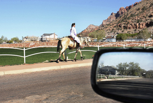 Scott Sommerdorf | The Salt Lake Tribune
A woman rides a horse up Center Street in Colorado City toward the Canaan Mountains on a quiet day in 2008. Non-profit organization Holding Out Help will open a new community center Oct. 19 in the Hildale, Utah, and Colorado City, Ariz., region.