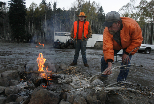 Scott Sommerdorf   |  The Salt Lake Tribune
Val Reeves, right, tends to the fire in camp as his hunting mates are out searching for deer near Soapstone Basin just off the Mirror Lake Highway, early Saturday morning, October 19, 2013.Saturday, October 19, 2013. Dennis Kunz is at center.