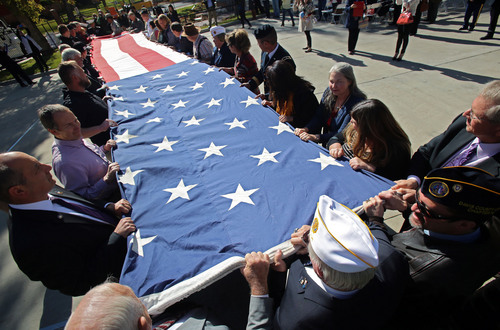 Francisco Kjolseth  |  The Salt Lake Tribune
Gold star parents, veterans, family and dignitaries gather to fold and retire a 28 by 38 ft flag that toured the country alongside the Utah Fallen Warrior Memorial, dedicated at Fort Douglas on the University of Utah campus on Monday, Oct. 21, 2013. A big chunk of foundation from the World Trade Center, which is the key featured in the memorial, has been on a statewide tour for several weeks before its final resting place at the Fort Douglas Museum.