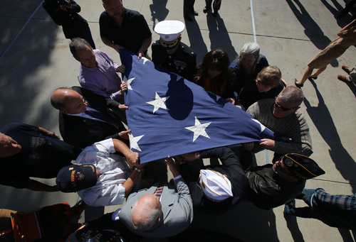 Francisco Kjolseth  |  The Salt Lake Tribune
A large American flag is folded and retired before following a tour alongside the Utah Fallen Warrior Memorial, dedicated at Fort Douglas on the University of Utah campus on Monday, Oct. 21, 2013. A big chunk of foundation from the World Trade Center, which is the key featured in the memorial, has been on a statewide tour for several weeks before its final resting place at the Fort Douglas Museum.