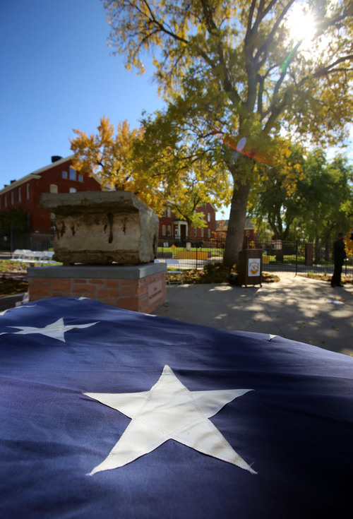 Francisco Kjolseth  |  The Salt Lake Tribune
The Utah Fallen Warrior Memorial reaches its final resting place alongside a large American flag following the dedication at Fort Douglas on the University of Utah campus on Monday, Oct. 21, 2013. A big chunk of foundation from the World Trade Center, which is the key featured in the memorial, has been on a statewide tour for several weeks before its arrival at the Fort Douglas Museum.