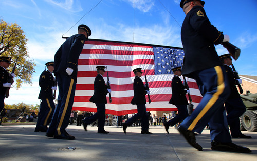 Francisco Kjolseth  |  The Salt Lake Tribune
Members of the Utah National Guard Honor Guard rifle squad march past the 28 by 38 ft flag that toured the country alongside the Utah Fallen Warrior Memorial. The memorial was dedicated at Fort Douglas on the University of Utah campus on Monday, Oct. 21, 2013. A big chunk of foundation from the World Trade Center, which is the key featured in the memorial, has been on a statewide tour for several weeks before its final resting place at the Fort Douglas Museum.