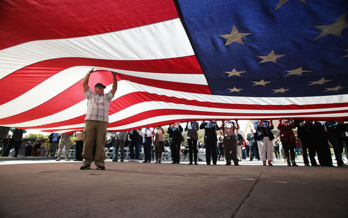 Francisco Kjolseth  |  The Salt Lake Tribune
Wayne Daley of Centerville, a Vietnam veteran holds up the center of the United States flag as it is pulled down to be folded and retired following a tour alongside the Utah Fallen Warrior Memorial. The memorial was dedicated at Fort Douglas on the University of Utah campus on Monday, Oct. 21, 2013. A big chunk of foundation from the World Trade Center, which is the key featured in the memorial, has been on a statewide tour for several weeks before its final resting place at the Fort Douglas Museum.