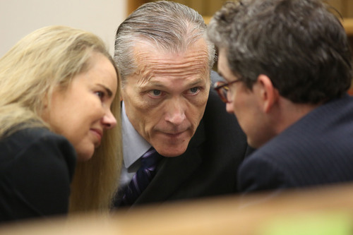 Pleasant Grove physician Martin MacNeill, center, charged with murder for allegedly killing his wife, Michele MacNeill in 2007 so he could continue and extramarital affair, speaks with defense attorney's Susanne Gustin and Caleb Proulx in Judge Derek Pullan's 4th District Court in Provo on Friday, Oct. 25, 2013. (AP Photo/The Salt Lake Tribune, Francisco Kjolseth)