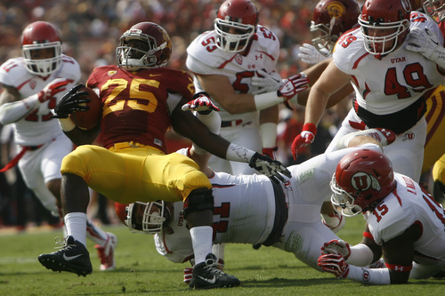 Chris Detrick  |  The Salt Lake Tribune
USC Trojans running back Silas Redd (25) is tackled by Utah Utes linebacker Jared Norris (41) during the first half game at the The Los Angeles Memorial Coliseum Saturday October 26, 2013. USC is winning the game 16-3.