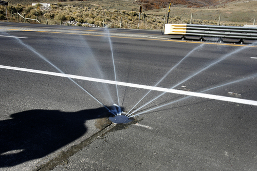 Scott Sommerdorf   |  The Salt Lake Tribune
A spray of chemicals is ejected from this submerged sprinkler head just off the roadway that de-ices the bridge near Deer Creek Dam. The Utah Department of Transportation has a system that detects when ice is likely to form on a bridge or highway and turns on a sprinkler that sprays de-icing fluid onto the road surface.