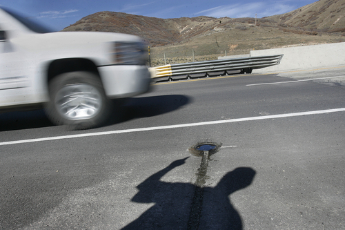 Scott Sommerdorf   |  The Salt Lake Tribune
A  Utah Department of Transportation technician's shadow points at sprinkler that sprays chemicalsonto a roadway when a sensor determines that weather conditions conducive to icing are taking shape. Sensors start automatic sprinkler systems that spray de-icing fluid.