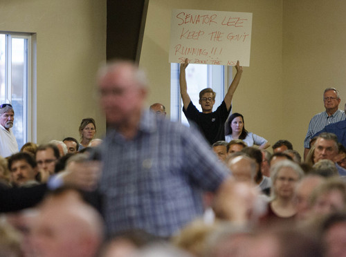 Trent Nelson  |  The Salt Lake Tribune
Doug Vowles holds up a sign, reading "Senator Lee: Keep the Gov't Running!!! Shut Down the NSA," as Senator Mike Lee meets with constituents at a townhall meeting in Spanish Fork, Wednesday August 21, 2013.