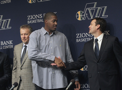 Al Hartmann  |  The Salt Lake Tribune
Dennis Lindsey, Utah Jazz general manager, right, shakes hands with power forward Derrick Favors, on his new multi-year contract extension during a press conference Monday October 28, 2013 in Salt Lake City. Jazz owner, Greg Miller, is at left.