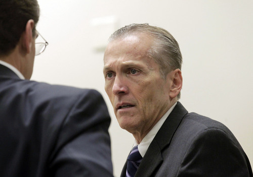 Pleasant Grove physician Martin MacNeill, charged with murder for allegedly killing his wife, Michele MacNeill in 2007, speaks with his defense lawyer Randy Spencerr, during his murder trial in Provo, Utah, Friday Nov. 1, 2013.  The murder trial of  the Utah doctor charged in his wife's death resumed Friday with testimony from medical experts about how they believe the 50-year-old woman died. (AP Photo/The Salt Lake Tribune, Al Hartmann, Pool)
