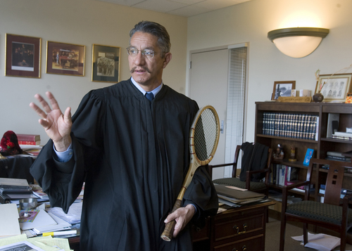 Juvenile court Judge Andrew Valdez has set up a tennis tournament with  inmates at San Quentin Prison and himself.  He's using the tennis courts to spread a message to inmates about the power of turning your life around.  It worked for him when he was a teenager.  He's holding  an old Wilson Jack Kramer autographed wooden tennis racket from the mid 1960's that someone gave him as a present.    Al Hartmann/Salt Lake Tribune     4/7/08
