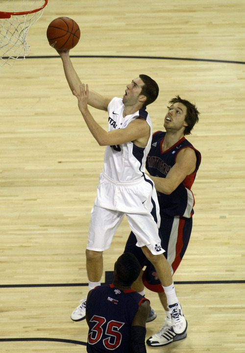 Chris Detrick  |  The Salt Lake Tribune
Utah State Aggies guard Preston Medlin (13) scores past St. Mary's Gaels guard Matthew Dellavedova (4) during the first half of the game at Dee Glen Smith Spectrum Thursday November 15, 2012. St. Mary's is winning the game 34-31.