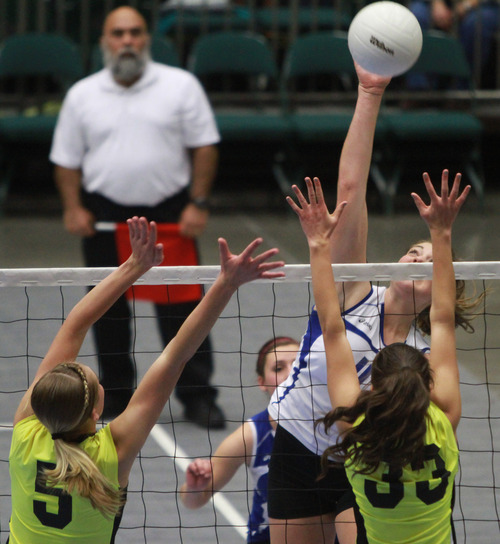 Rick Egan  | The Salt Lake Tribune 

Sara Morley (11) spikes the ball for San Juan High, as Dakota Robinson (5) and Rachell Bingham (33) defend, in the 2A volleyball State Championship, Saturday, November 2, 2013.