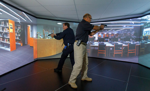 Trent Nelson  |  The Salt Lake Tribune
Unified Police Deputy Chief Shane Hudson, right, and Range Master Nick Roberts run through a school shooting simulation while demonstrating a new five-screen training simulator used to put officers through realistic situations in Salt Lake City, Thursday November 7, 2013.