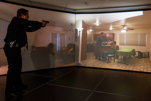 Trent Nelson  |  The Salt Lake Tribune
Unified Police Range Master Nick Roberts confronts a man holding a gun to a female hostage's head demonstrating a new five-screen training simulator used to put officers through realistic situations in Salt Lake City, Thursday November 7, 2013.