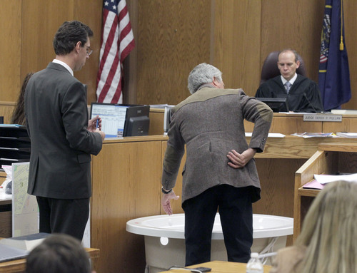 Al Hartmann  |  The Salt Lake Tribune
Ergonomist expert Brett Besser, center, testifies at Martin MacNeill murder trial in 4th District Court in Provo Utah Thursday November 7,  2013.   He explains to defense lawyer Randy Spencer stress to lower back and difficulty in lifting a heavy weight from a bathtub.  Judge Derek Pullan watches the demonstration.