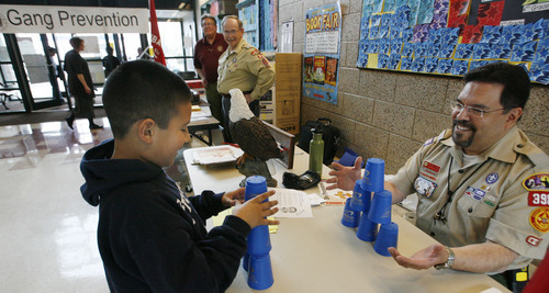 Salt Lake City - Michael Clara, of the Boys Scouts of America, plays a stacking game with Cub Scout Christian Miramontes, 8, during parent teacher conferences at Franklin Elementary School in Salt Lake City Wednesday Mar 25, 2009.  As part of Salt Lake City mayor Becker's Gang Reduction Program, the Prevention Committee decided to hold Youth and Adult Volunteer Recruitment / Gang Awareness Booths during parent teacher conference at various schools. Miramontes attends the school and Clara is a leader in the area. Steve Griffin/The Salt Lake Tribune 3/25/09