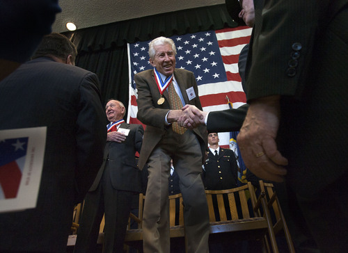 Steve Griffin  |  The Salt Lake Tribune

Veterans Edward Kay, Korea, left, and Ray Matheny, World War ll, shake hands with audience members during the Veterans Day Celebration at the University of Utah in Salt Lake City Monday, November 11, 2013. Several veterans were honored for their service during the event.