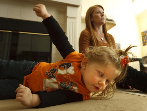 Leah Hogsten  |  The Salt Lake Tribune
Piper Koozer tries rolling onto her stomach on the floor of her new Colorado apartment. Her parents, Tennesseans Annie and Justin Koozer relocated in order to obtain a cannabis oil that has proven effective at calming intractable seizures.