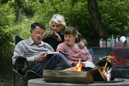 Gary, Carolyn and Amy Ford, right, of American Fork read together around the campfire after setting up camp in Little Mill Campground in American Fork Canyon. A recently released study by The Outdoor Foundation sponsored by The Coleman Company said that 38 million Americans, about 13 percent of the population over age 6, went camping at least once last year. However, camping participation is down from 2011, when 42.5 million Americans, or 15 percent of the U.S. population, camped. Tribune File Photo
