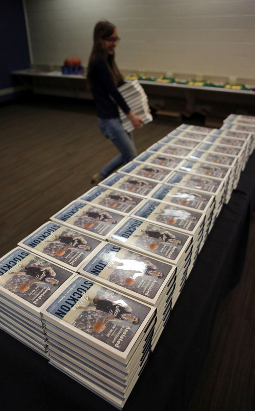 Francisco Kjolseth  |  The Salt Lake Tribune
Maurine Anderson, a social media intern for Deseret Book gets books ready for signing by Former Utah Jazz player John Stockton following a press conference at Energy Solutions Arena to promote his new book on Friday, Nov. 15, 2013.