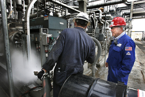 Scott Sommerdorf  |  File photo | The Salt Lake Tribune             
Lynn Keddington, left, refinery manager for the Holly Refining and Marketing Company-Woods Cross plant,  speaks with pump mechanic Mitch Bowles at its West Bountiful plant in 2012. State regulators have approved the oil refinery's plans to greatly expand to process more waxy crude pouring out of the Uinta Basin.