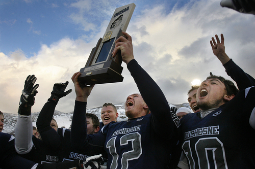 Scott Sommerdorf   |  The Salt Lake Tribune
Duchesne QB Trent Roberts hoists the 1A state trophy as he and other team mates including RB Matt Muir, right celebrate their win over Rich. Duchesne defeated Rich 14-13 to win the 1A state championship, played at Weber State University in Ogden, Utah, Saturday November 16, 2013..