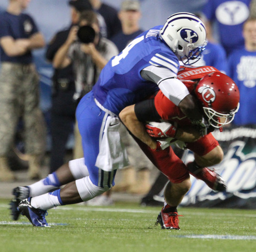 Rick Egan  | The Salt Lake Tribune 

Utah Utes running back James Poole (34) is pulled down by Brigham Young Cougars defensive back Robertson Daniel (4) for BYU  to face The University of Utah, at Lavell Edwards Stadium, Saturday, September 21, 2013.