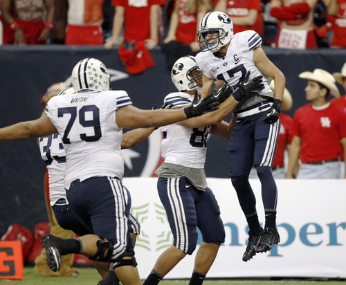 BYU's Skyler Ridley (17) celebrates his game-winning touchdown reception with Kaneakua Friel (82) and Makaaki Vaitai (79) during the second half of an NCAA college football game, Saturday, Oct. 19, 2013 in Houston. BYU defeated Houston, 47-46. (AP Photo/Eric Christian Smith)