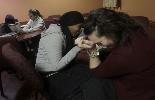 Leah Hogsten  |  The Salt Lake Tribune
Falza Dalmar, 14, giggles with her reading tutor Jeanette Smith while completing homework. Refugees from Somalia are tutored every Tuesday evening at Discovery Christian Community church under the direction of Danielle and Danjuma Alcala. During the holidays they give their 70 students Christmas gifts ó including clothing. The program, called "Because He First Loved Us" is all volunteer and relies on private funding.