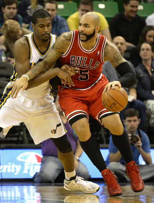 Rick Egan  | The Salt Lake Tribune 

Chicago Bulls power forward Carlos Boozer (5) tries to move the ball inside, as Utah Jazz power forward Derrick Favors (15) defends, in NBA action, as theJazz faced the Chicago Bulls, at the EnergySolutions Arena, Monday, November 25, 2013.