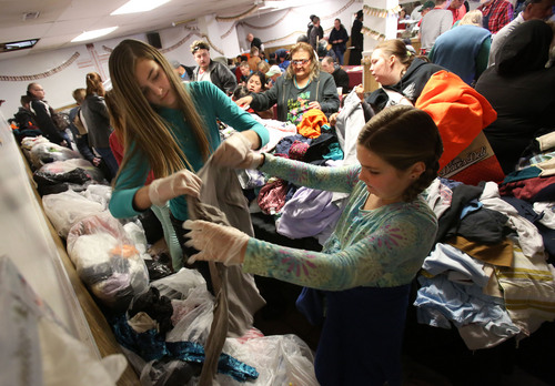 Francisco Kjolseth  |  The Salt Lake Tribune
Abbie Smith, 14, left, and her sister Amelia, 9, of Layton, help sort clothes as the Rescue Mission of Salt Lake serves hundreds of meals and gives away thousands of coats and warm clothes to Utah's homeless and low-income families Tuesday.