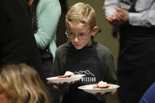 Francisco Kjolseth  |  The Salt Lake Tribune
Derek Spendlove, 10, of Sandy hands out pie as the Rescue Mission of Salt Lake serves hundreds of meals and gives away thousands of coats and warm clothes to Utah's homeless and low-income families at the annual Day-Before-Thanksgiving Banquet. The Mission also supplied haircuts, flu shots, hot showers and hygiene items along with live music and addiction counseling for the Mission's Thanksgiving guests.