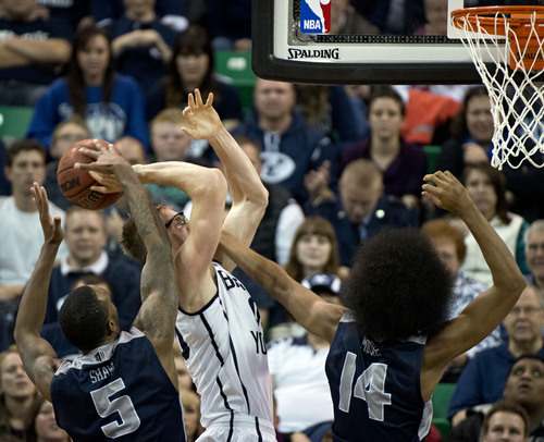 Lennie Mahler  |  The Salt Lake Tribune
BYU's Erik Mika draws a foul from Utah State's Jalen Moore as Jarred Shaw helps on defense in the second half of their game at EnergySolutions Arena in Salt Lake City, Saturday, Nov. 30, 2013.